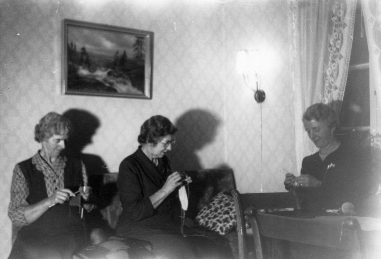 Søstrene Lund med håndarbeid, fra venstre Hilda, Norunn og Magnhild. Bildet er tatt i stua på Elvheim på 1960–70-tallet. Fotograf: Ukjent. Fotoeier: Åsen Museum og Historielag. 